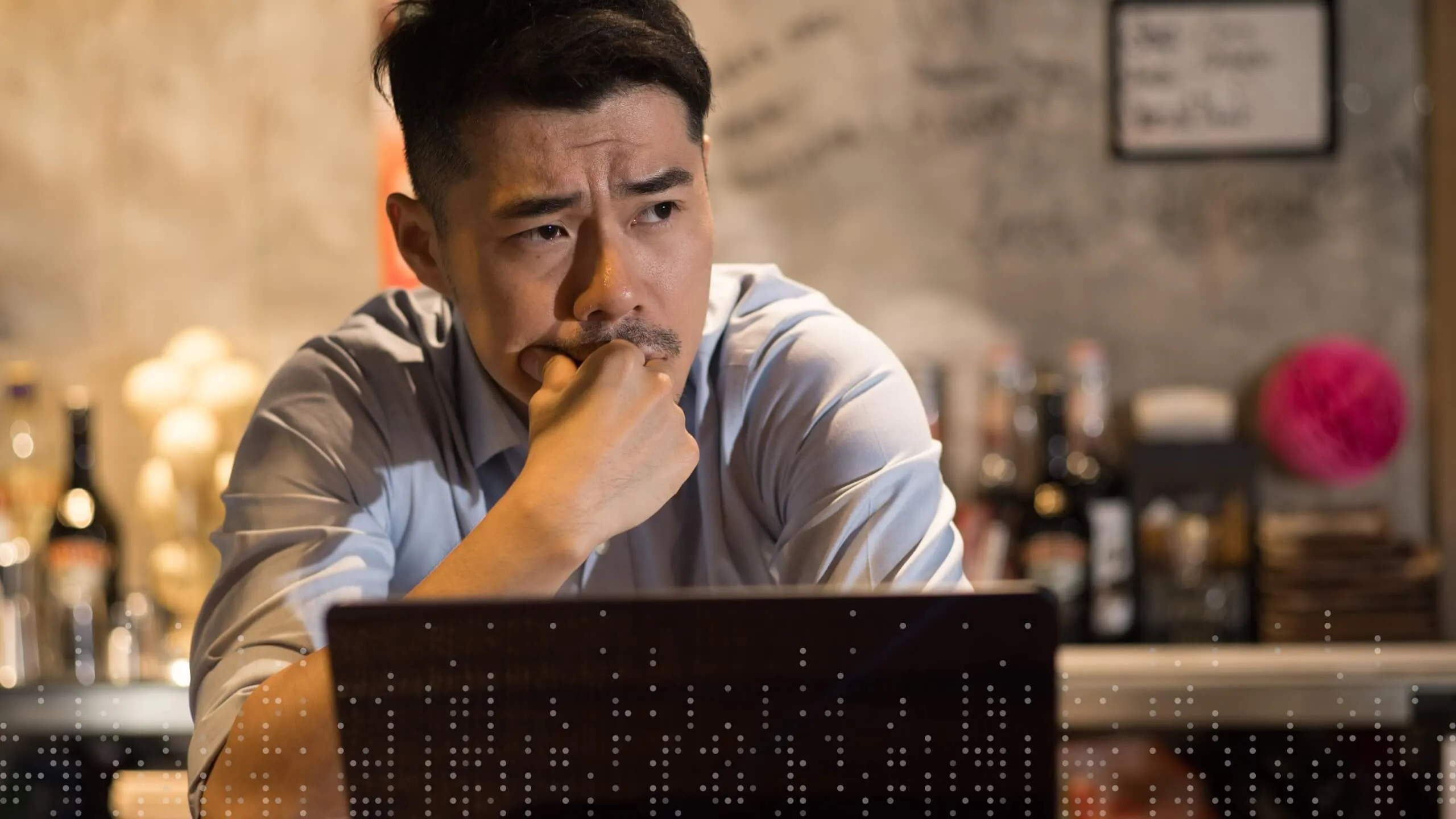 Thoughtful small business owner in front of laptop