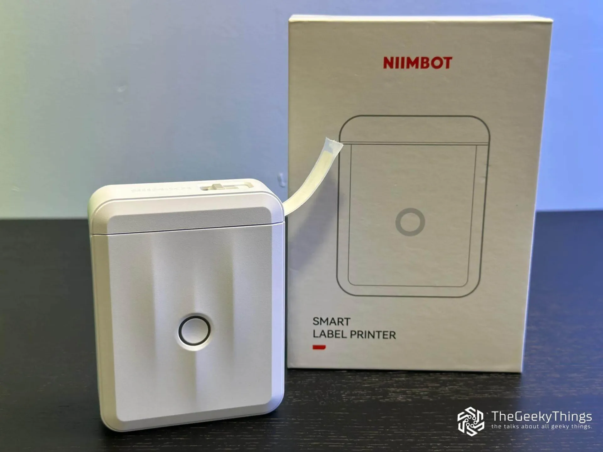 Niimbot label maker D110 with printed sticker and its box on the desk