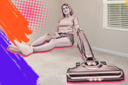 Woman with a stick vacuum sitting in room corner