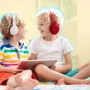 Two kids with tablets and over ear headphones
